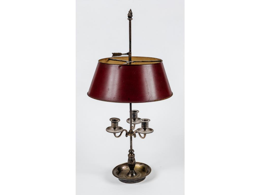 Lampe bouillote de style Empire en métal argenté (en partie désargenté), éclairant à trois binets. Abat-jour en tôle rouge. ( Non électrifié, avec sa clé et son balancier). Hauteur totale : 67 cm.