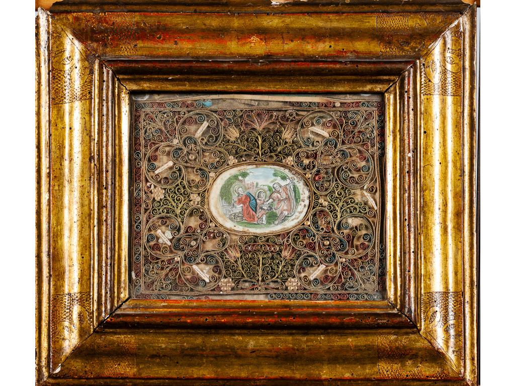 Composition encadrée sous verre composée d'une gravure rehaussée figurant la Sainte famille dans un entourage de paperoles. (Piqûres, manques et parties vermoulues au cadre). Dim : 18.5 x 23 cm.