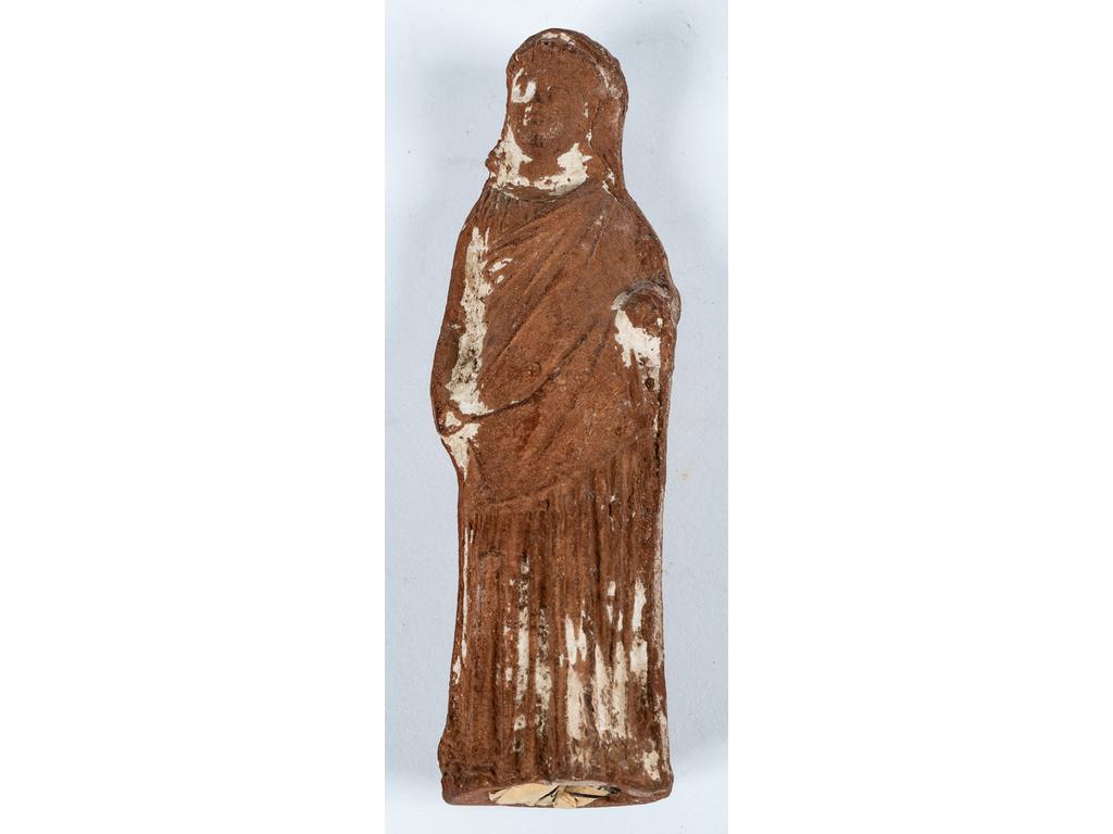 Figurine représentant une jeune femme vêtue d'un himation et d'un chiton talaire. Terre cuite ocre. Dépôt calcaire. Atelier égyptien? Période hellénistique. H:11,8 cm.