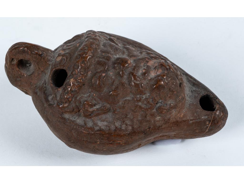 Belle lampe à huile en forme de tête de Silène couronné. Elle est inscrite au revers