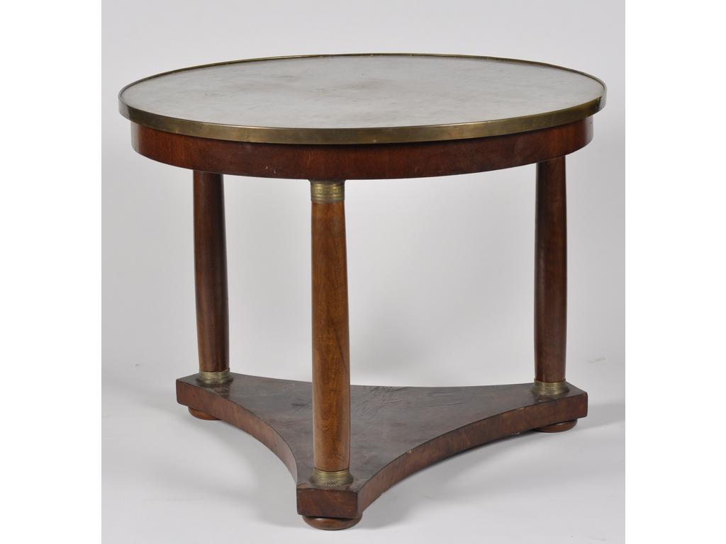 Large guéridon tripode en acajou et placage d'acajou. Plateau de marbre blanc soutenu par trois colonnes baguées reposant sur une plinthe. Garniture de laiton. Epoque XIXème siècle. (chocs, manques et soulèvement). Haut : 79 cm et Diam :100 cm.