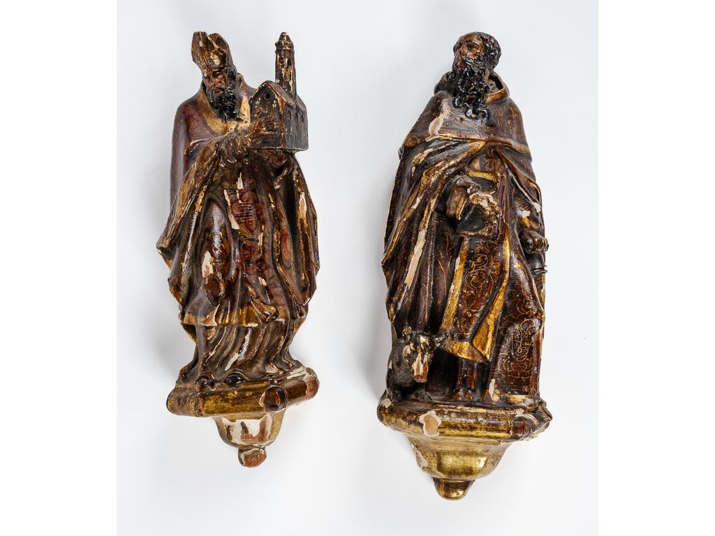 Deux petites sculptures en bois polychrome et doré représentant un ecclésiastique présentant l'Eglise et Saint-Antoine. Reposant chacun sur un dai. Epoque vers 1700. (Eclats à la dorure et à la peinture et petits manques). Hauteur : 30 et 31 cm.