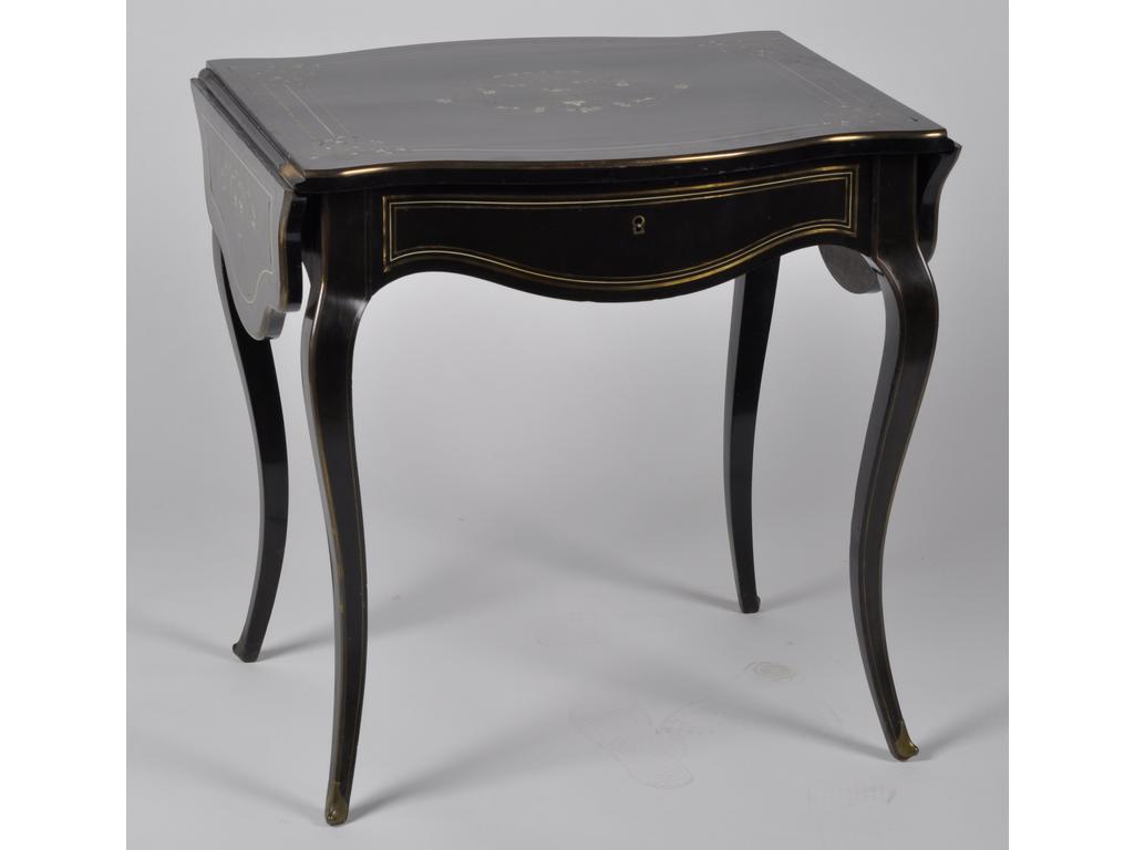 Petite table à volets de style Napoléon III en bois noirci à décor de vase fleuri en incrustation de nacre et laiton. Elle ouvre par un tiroir en ceinture et repose sur quatre petits pieds cambrés. Estampillée de A.BASTET à Lyon. Dim : 73 x 73 x 63 cm.
