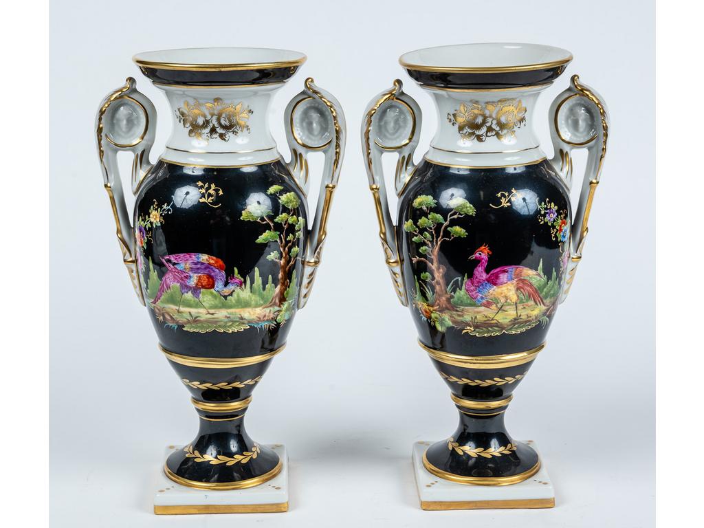Paire de vases de forme balustre en porcelaine à décor de volatiles sur fond noir et blanc et rehauts dorés. Hauteur : 31 cm.