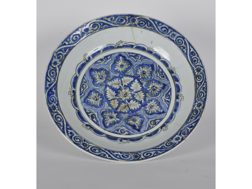 TURQUIE ou IRAN : Grand plat en terre-cuite siliceuse à décor émaillé de feuillages stylisés sur fond bleu. Epoque XIXème siècle. (aile cassée et recollée et fêles). Diamètre : 41 cm.