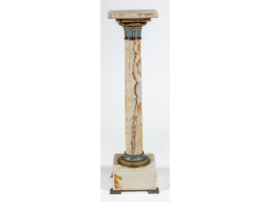 SUR FOLLE ENCHERE : Une colonne en onyx ornée d'un chapiteau et d'une base en laiton doré et émail cloisonné. Hauteur : 104 cm. Plateau : 27 x 27 cm.