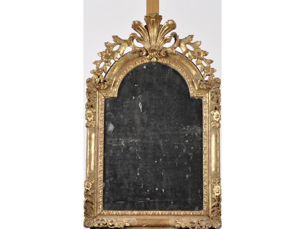 Miroir en bois sculpté et doré surmonté d'un fronton ajouré à décor de panache, rinceaux, feuillages et fleurs. Epoque XVIIIème siècle. (Infimes éclats et petites restaurations). Dim : 85 x 54 cm.