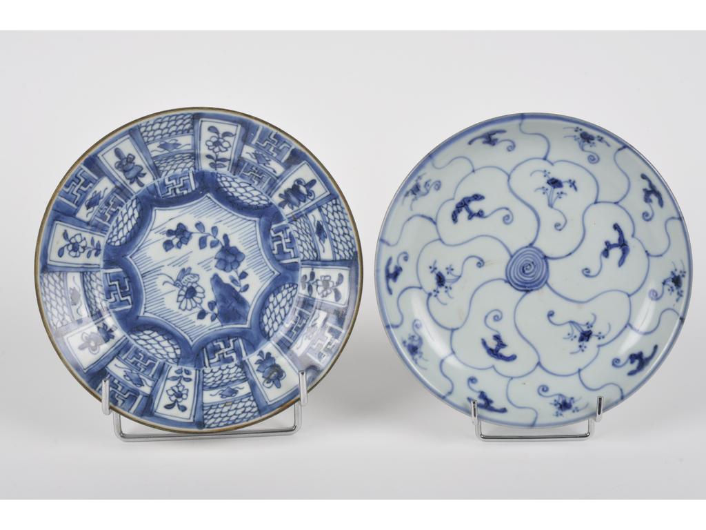 CHINE : Deux assiettes en porcelaine à décor bleu et blanc de fleurs et végétaux stylisés. (Une avec quelques éclats). Diamètre : 20.5 et 21 cm.