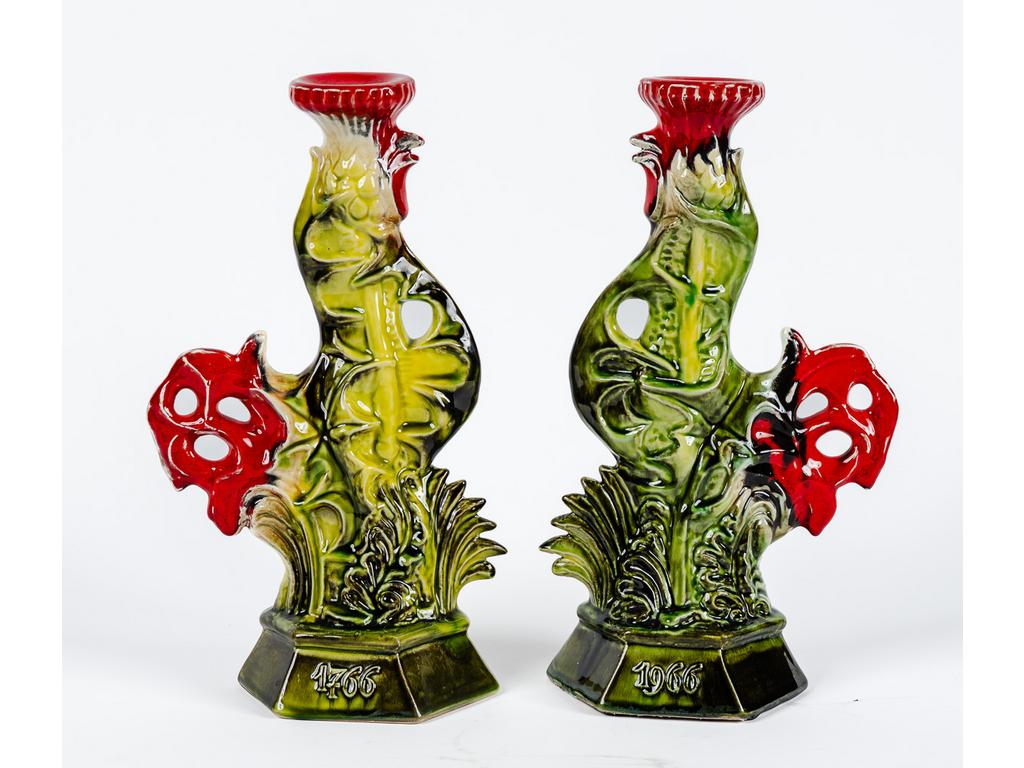 LUNEVILLE : Paire de flambeaux en barbotine à décor de coqs et chardons polychrome. Socles datés 1766-1966. Modèle d'après Michel JAMAR à l'occasion du bicentenaire de la réunion de la Lorraine et du Barrois à la France. (Un avec queue cassée-recollé). Hauteur : 31 cm.