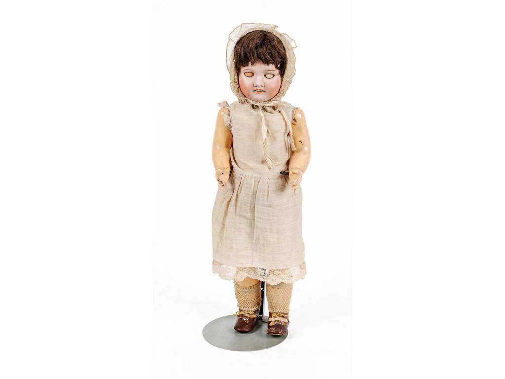 Poupée SFBJ, tête en porcelaine, les yeux dormeurs en verre et bouche ouverte. Corps articulé à tête pivotante et mécanisme de marche signée SFBJ Paris dans le moule. Taille 5. (Eclats aux mains et doigts cassés. Usures aux vêtements). Hauteur : 52 cm.