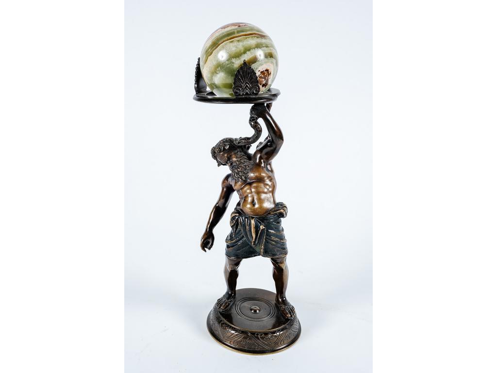 Sujet en bronze patiné représentant le satyre Silène tenant un serpent supportant une boule en onyx. Hauteur totale : 33 cm. (Une patte du support de la boule à ressouder)