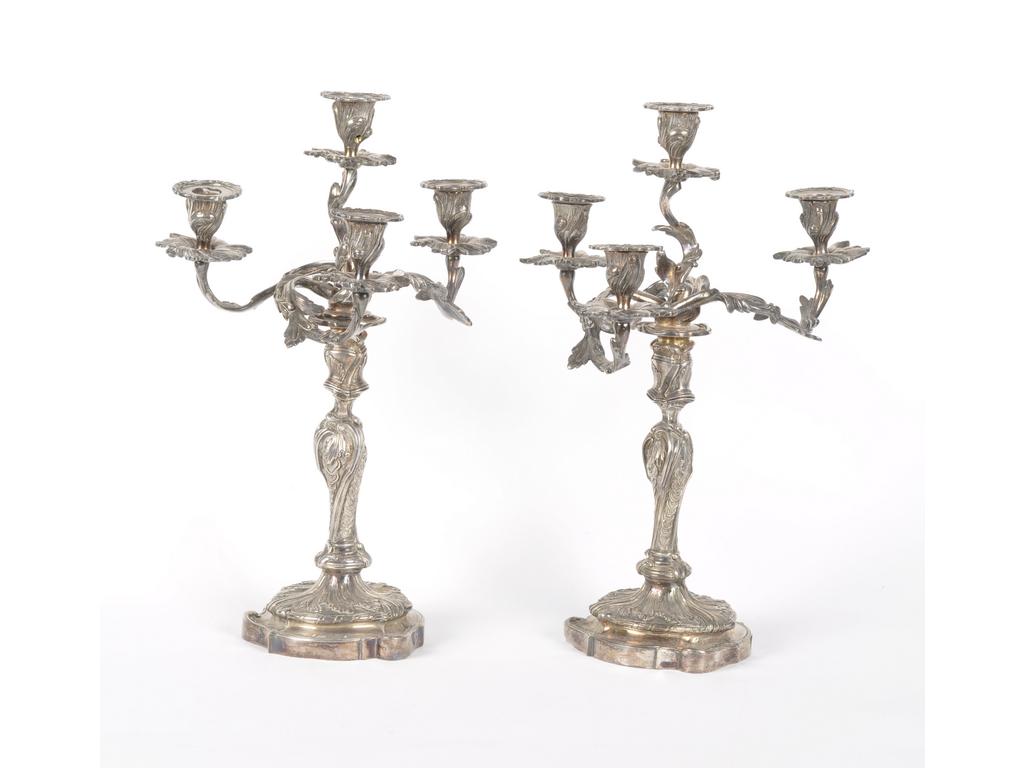 Paire de candélabres de style Louis XV en métal argenté, éclairant à quatre lumières ornées de feuillages. Hauteur : 43 cm (Bobèches centrales percées à l'électricité).
