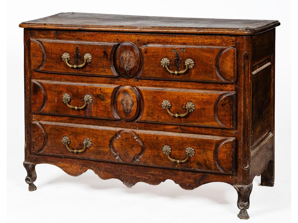 Commode en bois naturel dépoque Louis XV ouvrant par quatre tiroirs en façade et reposant sur un petit piètement cambré à enroulement. (Traces dinsectes xylophages, entrées de serrure absentes, accidents et manques aux extrémités des tiroirs, en l'état). Dimensions 88 x 122 x 54 cm.