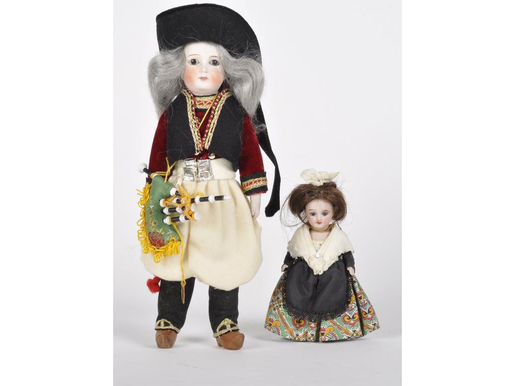 Réunion de deux mignonettes : L'une de marque UNIS FRANCE (marquée sur la nuque) tout biscuit habillée en Arlésienne, les yeux bleus fixes et la bouche ouverte. Environ 12 cm. (Etat intacte). La deuxième, plus grande, dans un costume régional breton. La tête et les avant-bras en biscuit et le reste du corps en tissu. Les yeux noirs fixes et la bouche fermée. Environ 23 cm. (Pas d'accidents à la tête).