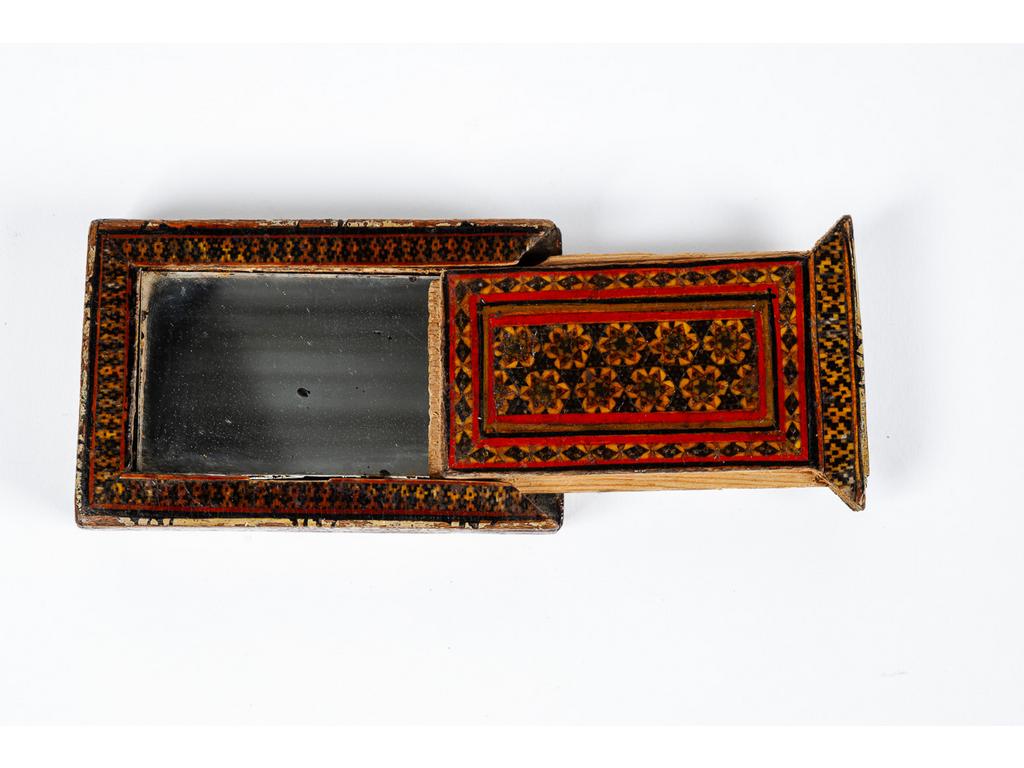Petit miroir de voyage à double faces et parois coulissantes en bois laqué à décor polychrome stylisé dans le goût de Kadjar. (Manques et usures). Dim : 11 x 7 x 2 cm.