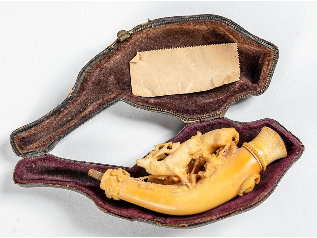 Pipe en écume à décor de cervidés dans son étui en cuir. Fin XIXème siècle. (incomplète). Longueur : 10 cm.