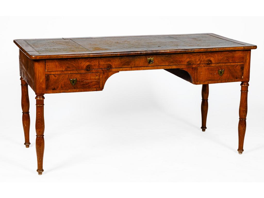 Bureau plat d'époque Louis-Philippe en bois fruitier et placage, ouvrant en ceinture par trois tiroirs. Plateau gainé de cuir reposant sur quatre pieds Jacobs. (Un pied cassé et restauré, placage restauré, usures au plateau). Dim : 74 x 147 x 70 cm.