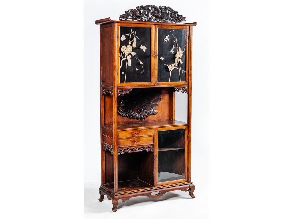 Meuble cabinet de style Extrême Oriental en bois ouvrant par deux tiroirs, trois portes dont une avec verre biseauté. Les deux portes en partie haute sont composées de deux panneaux en bois laqué noir incrustés et ornés de branchages et oiseaux en os sculpté à haut relief. (Quelques oiseaux restaurés avec de la résine, usures, manques et tâches d'usage). Epoque fin XIXème siècle. Dim : 200 x 98 x 37 cm.