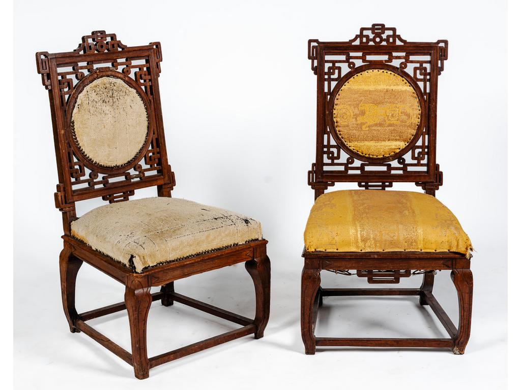 Paire de chaises en bois sculpté et ajouré de style Extrême Oriental (Les dossiers en partis accidentés et recollés, la garniture en tissus abîmée). Hauteur : 95 cm.
