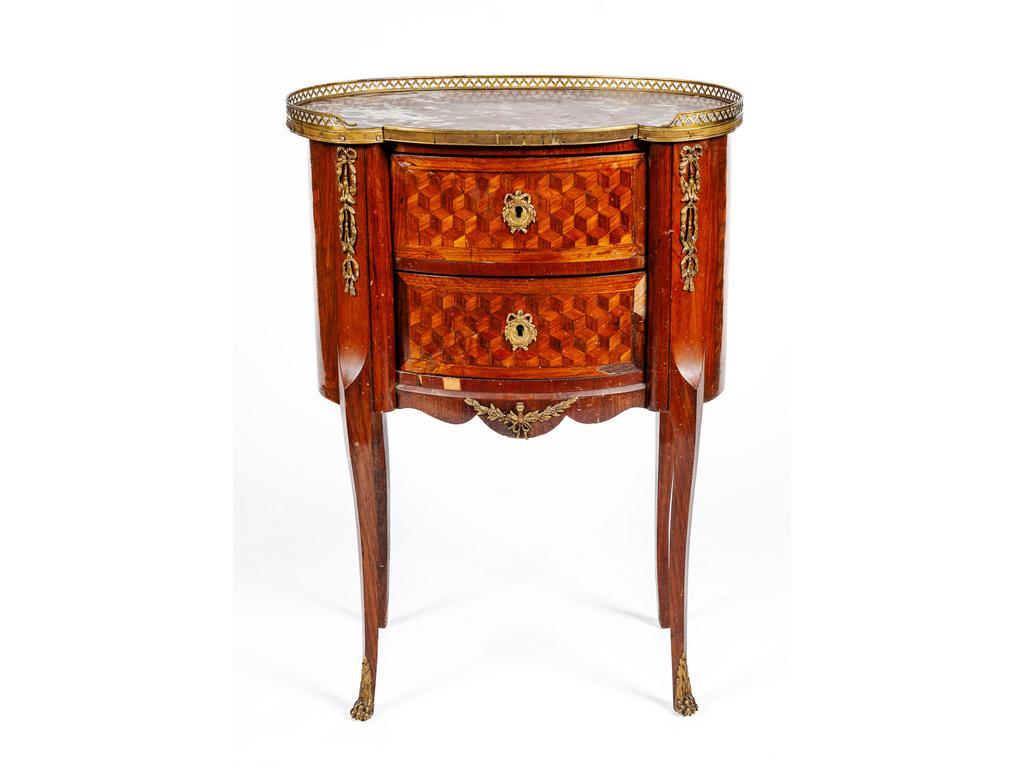 Petite table chiffonnière de style Transition en bois et marqueterie de cubes, ouvrant par deux tiroirs. Plateau de forme rognon en marbre du Languedoc orné d'une galerie en laiton. (Manques au placage). Dim : 85 x 61 x 40 cm.
