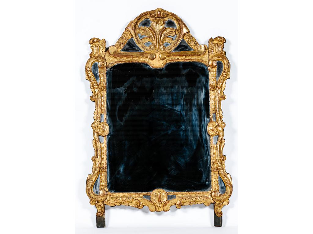 Un miroir à pareclose en bois sculpté et redoré à décor de coquilles, agrafes et feuillages. Epoque XVIIIème siècle. (Petites restaurations). Dim : 121 x 79 cm.