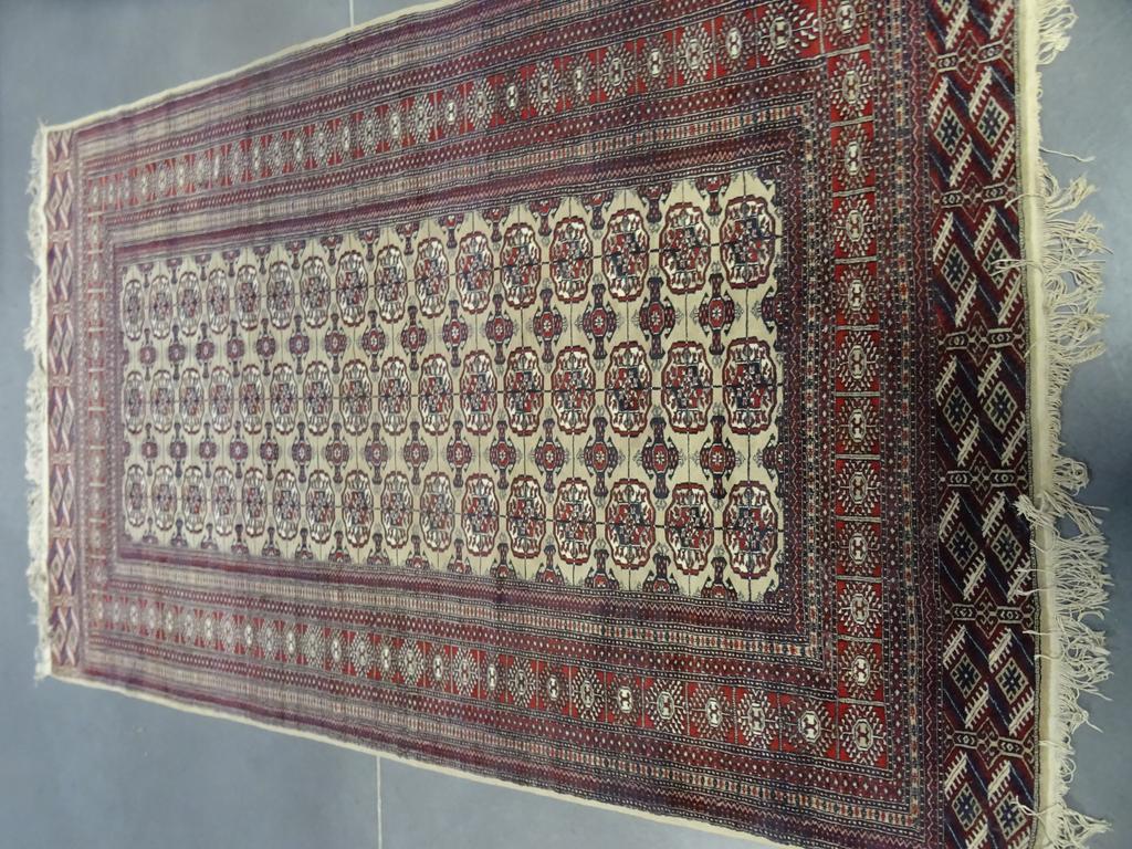 Tapis à décor BOUKHARA en laine à décor de ghuls. Bon état. Dim : 289 x 186.5 cm.