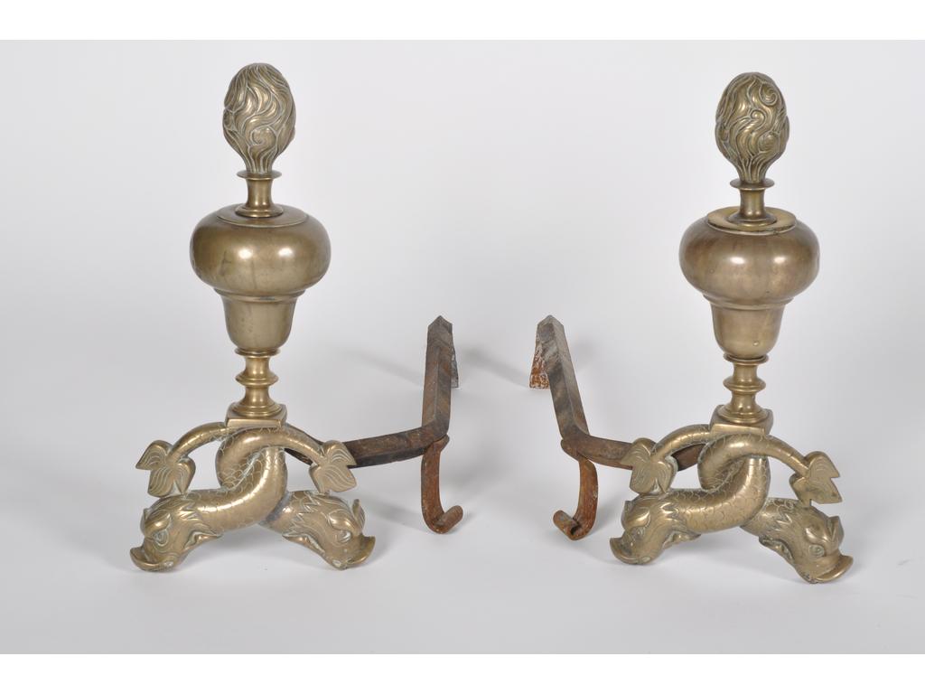 Paire de chenets en bronze et laiton à décor de pots à feu de forme balustre reposant sur des dauphins adossés. Epoque XVIIème siècle. Hauteur : 43 cm.