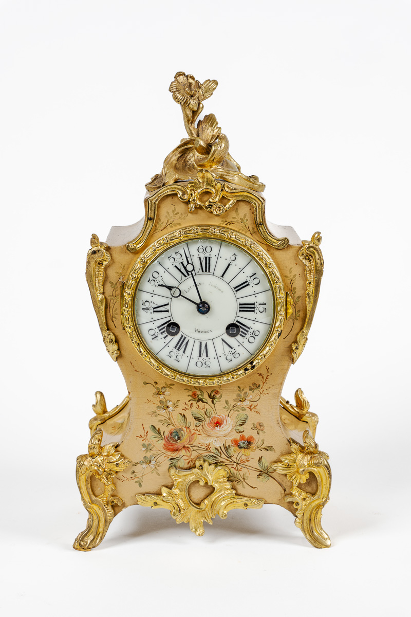 Petit cartel de style Louis XV en bois laqué à décor de fleurs dans le goût des vernis Martin. Cadran émaillé à chiffres arabes et romains, signé Laurence Frère à Béziers. (Éclats à la vitre de la lunette et petits sauts à la caisse). Hauteur : 31 cm.