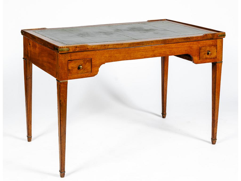 Table de tric-trac de style Louis XVI en acajou et placage d'acajou ouvrant par quatre tiroirs en ceinture et reposant sur quatre pieds fuselés et bagués. Plateau double-face gainé de feutre et de cuir doré découvrant un plateau de jeux incrusté d'os et de cornes teinté sur fond de palissandre. (Chocs et usures, un pied fortement piqué). Dim : 77 x 115 x 66.5 cm.