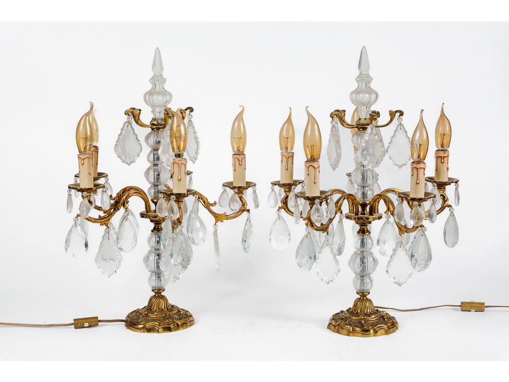 Paire de girandoles de style Louis XV en bronze, laiton et cristal éclairant par cinq bras de lumière ornés de pampilles. Epoque XXème siècle. (Percé à l'électricité). Hauteur : 58 cm.