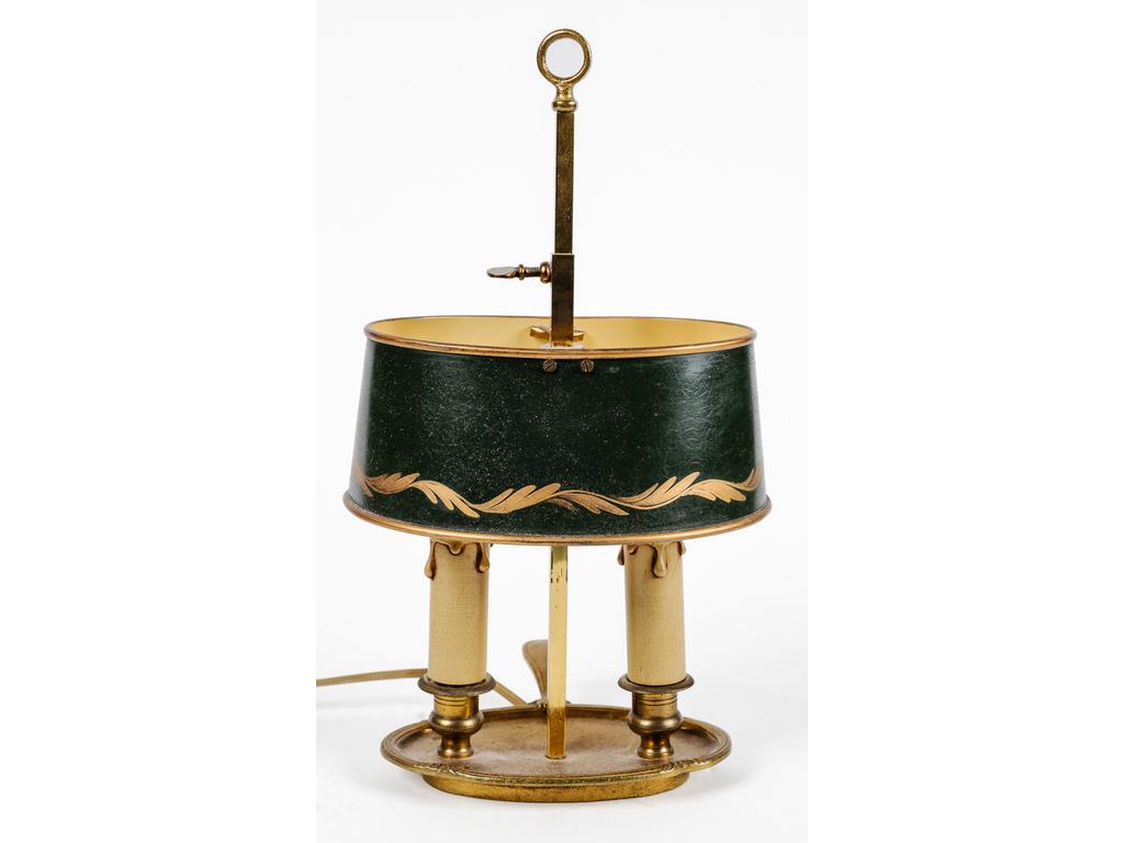 Petite lampe bouillotte en laiton et bronze éclairant par deux bras de lumière et surmonté d'un abat-jour en tôle laqué vert. Hauteur : 34 cm.
