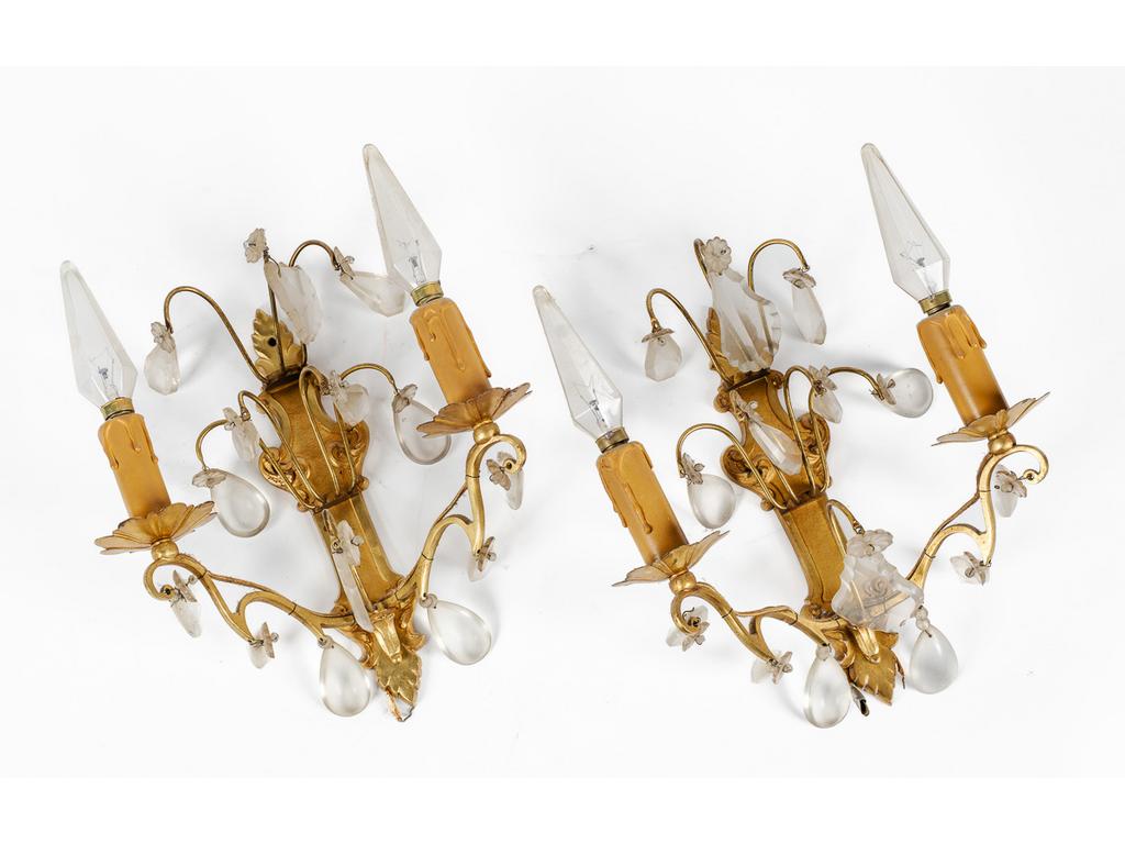 Une paire d'appliques en laiton éclairant par deux bras de lumière orné de pampilles. Epoque XXème siècle. Hauteur : 28 cm.