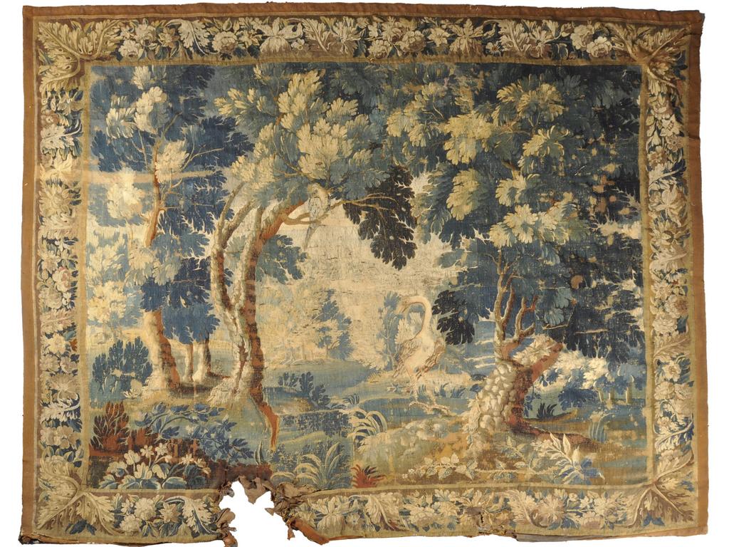AUBUSSON : Tapisserie en laine polychrome à décor d'une verdure ornée d'un grand échassier et d'un perroquet perché. Bordure ornée de guirlandes fleuries. Epoque début du XVIIIème siècle. (Partie basse très abîmée, déchirée avec manques, nombreuses reprises. Vendue en l'état). Dim : 265 x 310 cm.
