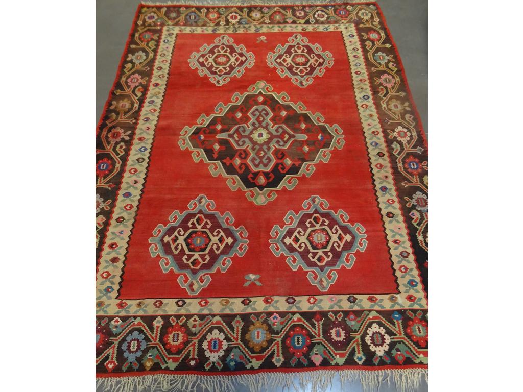 Grand tapis Kilim à décor de fleurs stylisées. (Usures). Dim : 298 x 212 cm.
