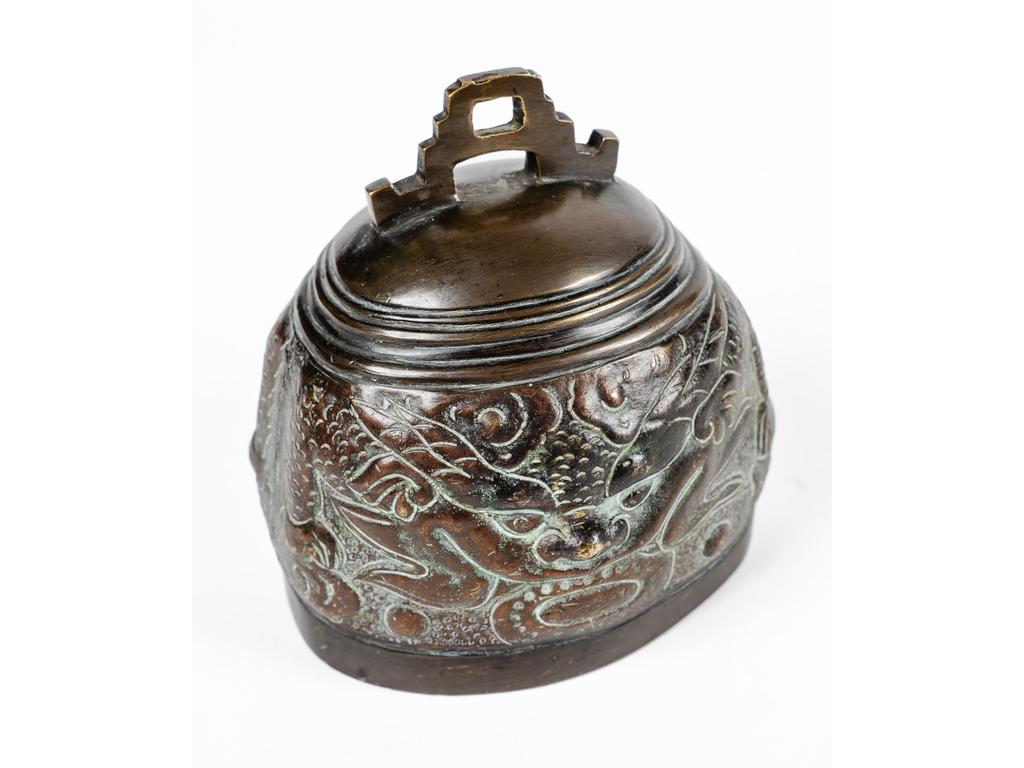 VIETNAM : Cloche en bronze patiné à décor de têtes de dragons. Dim 12 x 11 x 9 cm.