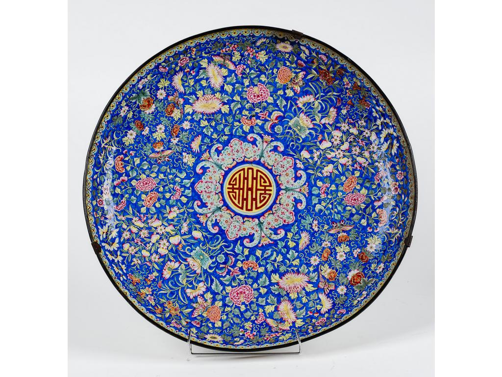 CHINE : Important plat en émail cloisonné à décor rayonnant de fleurs et papillons. Epoque XIXème siècle. (Restaurations, éclats et manques au dos du plat). Diamètre : 54.5 cm.