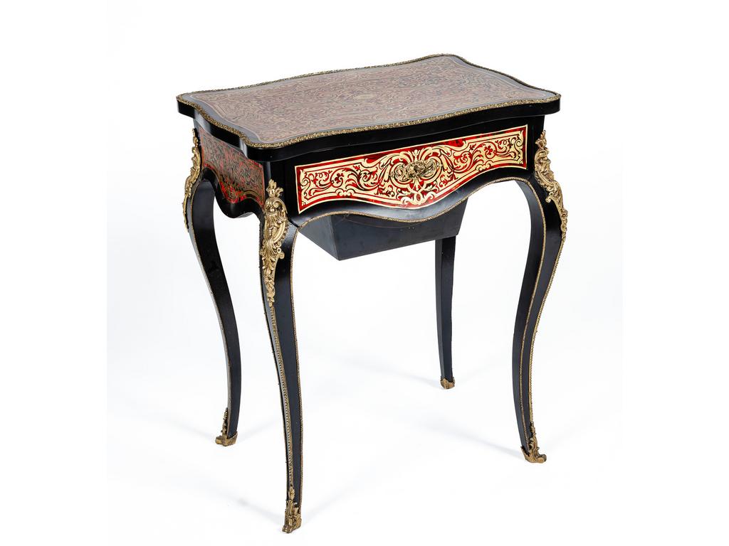 Petite table à ouvrage en bois noirci à décor marqueté d'incrustations de laiton sur fond d'écaille. Elle repose sur quatre pieds cambrés et ouvre par un abattant foncé d'une glace. Garniture de bronze. Epoque Napoléon III.