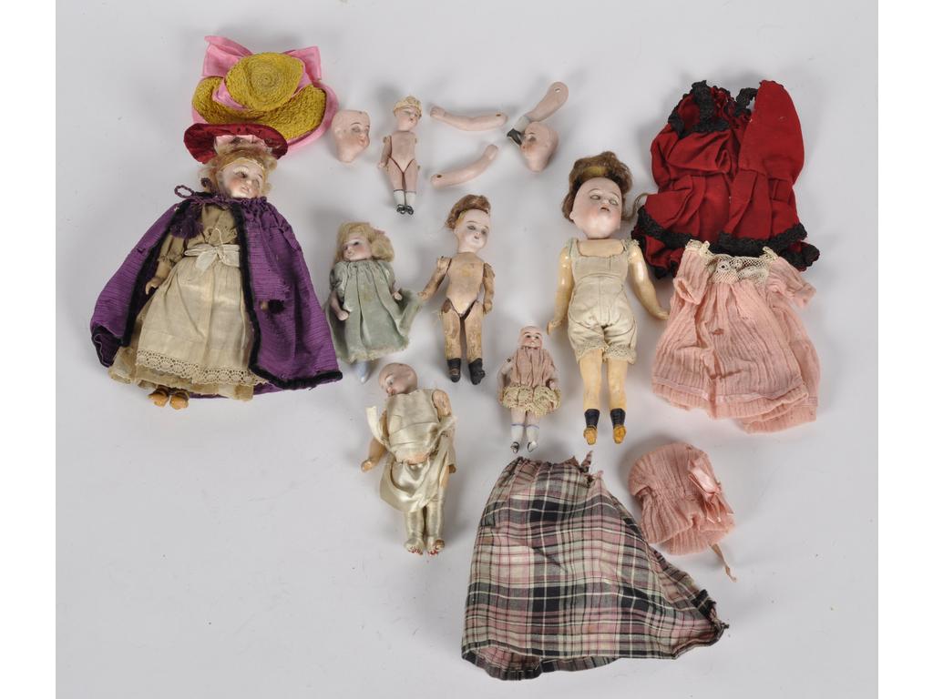 Ensemble de sept mignonettes dont quatre ont le corps semi-articulé en carton bouilli et la tête en porcelaine (une sans les yeux, état grenier). Et trois tout en biscuit (accidents et manques). Dimensions de 6 cm à 19 cm. On joint deux têtes (manque les yeux pour l'une), deux bras et deux jambes en biscuit, ainsi qu'un petit lot de vêtements artisanaux.