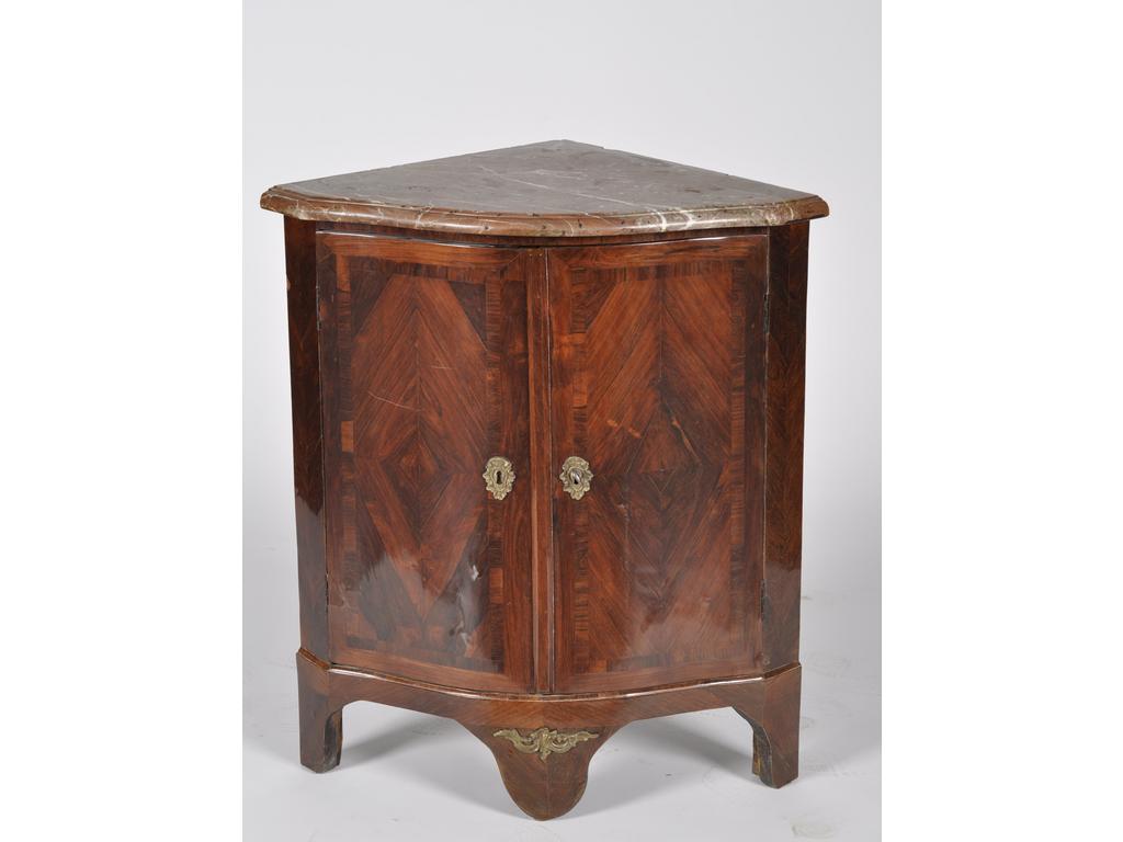 Encoignure d'époque Louis XV en placage de palissandre à façade galbée ouvrant par deux portes. Elle repose sur trois pieds et un cul de lampe. Plateau de marbre (éclats). Estampillé du monogramme