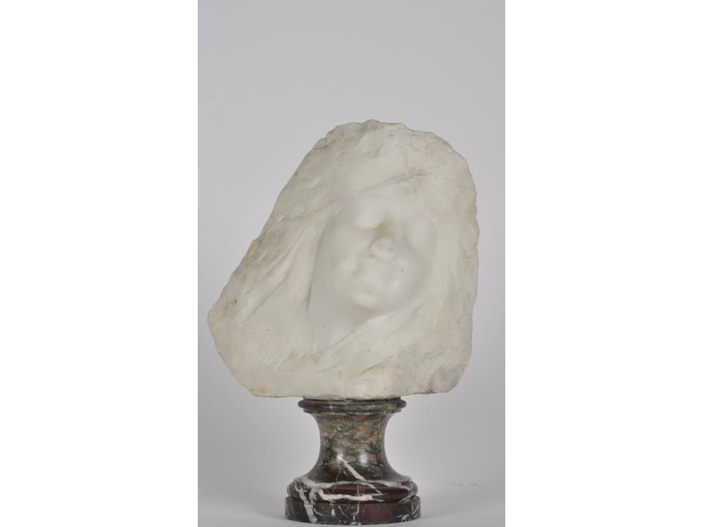 Sculpture en marbre blanc représentant le visage d'une femme endormie. Epoque 1900. Socle en marbre griotte. Non signée. Hauteur totale : 38 cm.