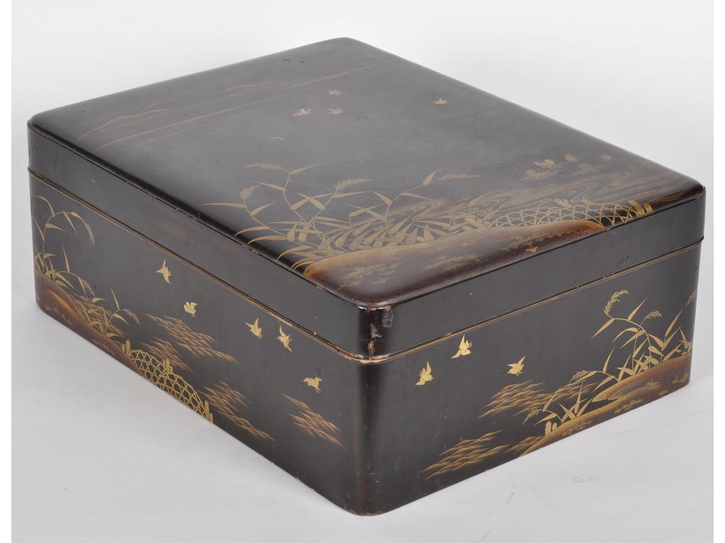 JAPON : Grand coffret en bois laqué et doré à décor sur le couvercle et les côtés de paysages fluviaux ornés d'oiseaux et feuillages sur fond noir. Intérieur poudré. Epoque 1900. (Quelques fentes, chocs et petits manques sur les rebords du couvercle et du coffret). Dim : 16 x 42 x 32 cm.