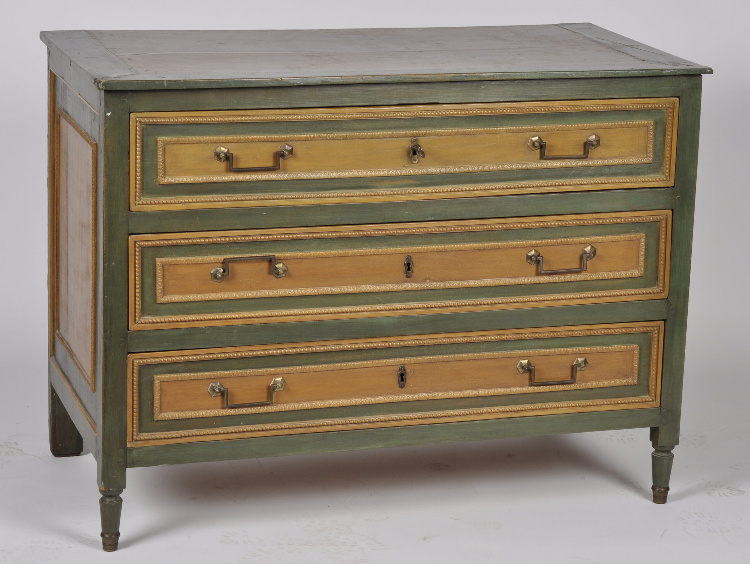 Commode de style Louis XVI en bois relaqué ouvrant par trois tiroirs et reposant sur des petis pieds antérieurs tournés. Dim : 90 x 121 x 64 cm.