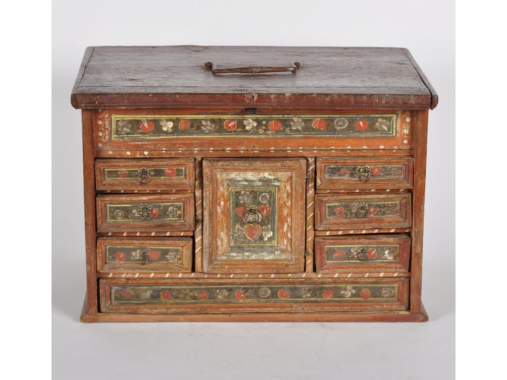 Petit cabinet en bois laqué à décor de fleurs, ouvrant en façade par sept tiroirs et une porte et surmonté d'un plateau ouvrant sur quatre compartiments. Travail dans le goût des colonies espagnoles de la fin du XVIIIème siècle. Dim : 31.5 x 45.5 x 32 cm.