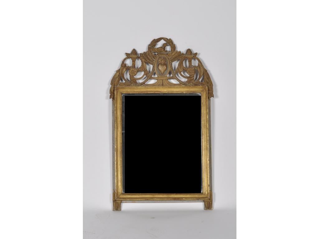 Petit miroir à fronton en bois sculpté, ajouré et doré à décor d'oiseaux, rinceaux feuillagés et sacré coeur. Epoque XIXème siècle. (Restaurations au fronton). Dim : 79 x 46 cm.