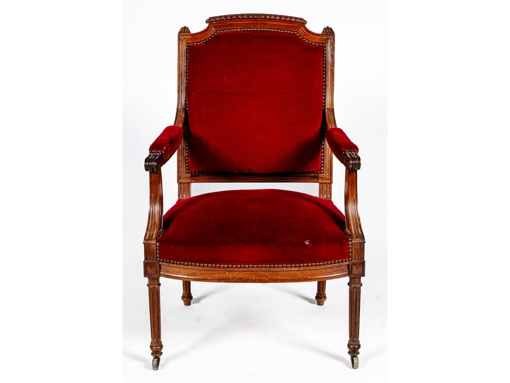 Fauteuil de style Louis XVI à dossier chapeau de gendarme en noyer et palissandre reposant sur quatre petits pieds cannelés. Garniture de velours.