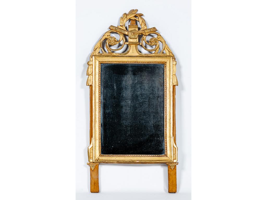 Petit miroir à fronton d'époque Louis XVI en bois sculpté et doré à décor de trophées de musique, de feuilles de laurier et rais de perles. (trous de xylophages). Dim : 90.5 x 45.5 cm.