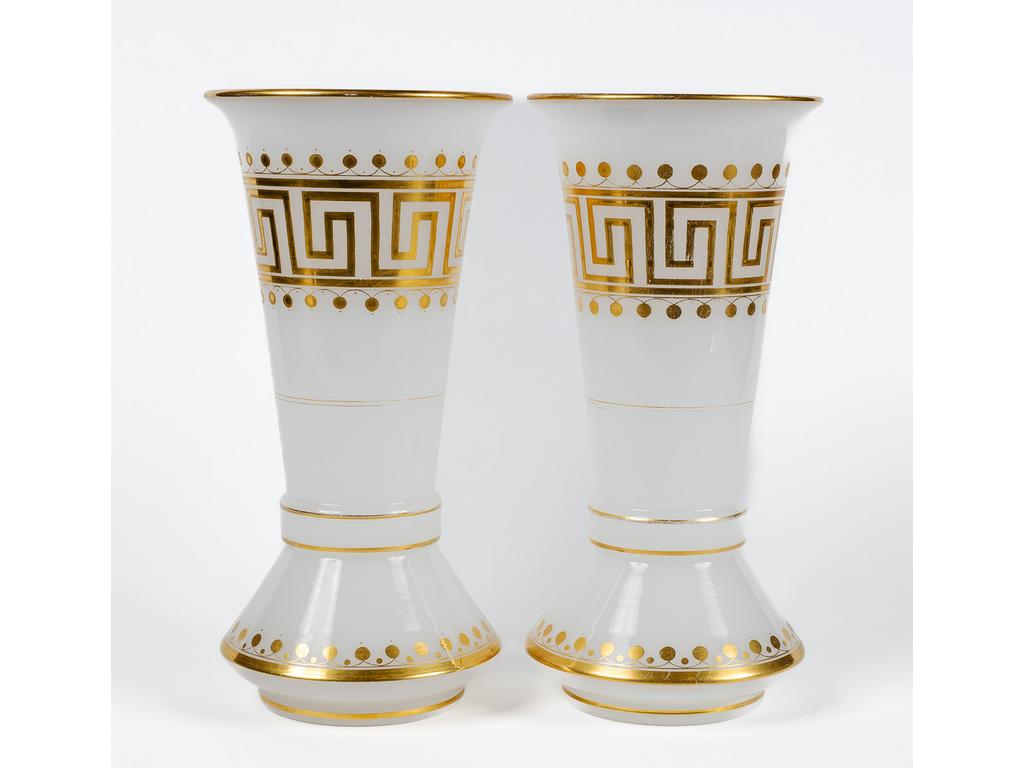 Une paire de vases cornets en opaline blanche et rehauts dorés à décor de frise de grecques et liserés. (Usures à la dorure). Hauteur : 30.5 cm.