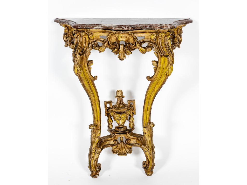 Petite console d'époque Transition Louis XV - Louis XVI, en bois sculpté, relaqué et doré. La ceinture galbée et ajourée de guirlandes de laurier et coquille. Petite traverse ornée d'une urne. Plateau de marbre (cassé et restauré). Dimensions : 81 x 70 x 31 cm. (renfort du linteau à l'arrière)