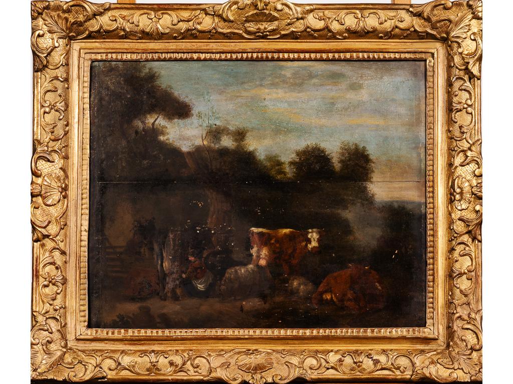 Ecole Flamande du XVIIIème siècle :  Bergère et troupeau. La traite. Huile sur panneau. (panneau en deux partie, quelques sauts de peinture et usures). Cadre ancien en bois redoré. Dim : 44 x 55 cm.