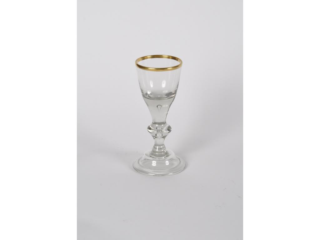 ALLEMAGNE : verre à pied en verre soufflé reposant sur un piédouche. Le buvant rehaussé d'un liseré doré. Epoque XIXème siècle. En bon état. Hauteur : 19 cm.